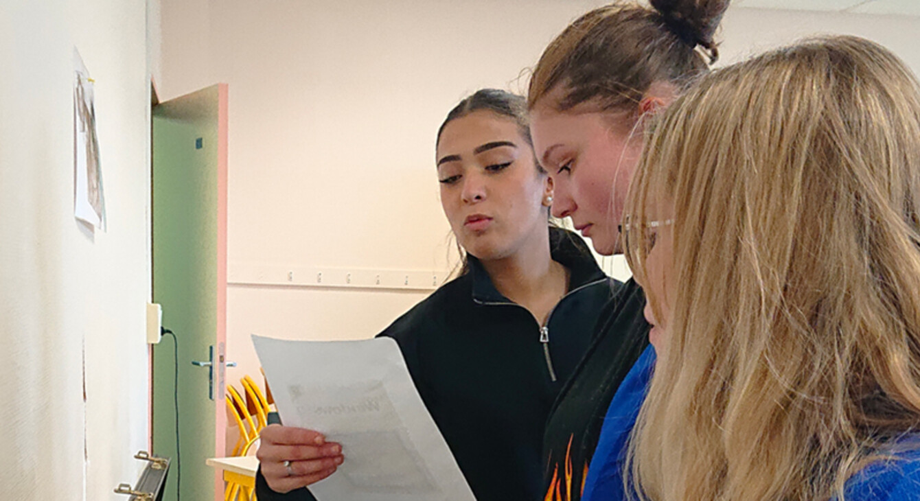 3 jeunes filles lisent un indice sur une feuille pour résoudre l'excape game au lycée Schuman de Metz