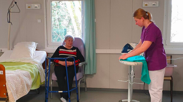 Une jeune fille fait preuve de professionnalisme et de bienveillance lors de la prise en charge de Claudine Thouraine qui joue le rôle d'une personne âgée avec une perte d'autonomie