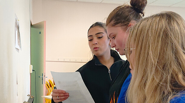 3 jeunes filles lisent un indice sur une feuille pour résoudre l'excape game au lycée Schuman de Metz