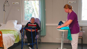 Une jeune fille fait preuve de professionnalisme et de bienveillance lors de la prise en charge de Claudine Thouraine qui joue le rôle d'une personne âgée avec une perte d'autonomie