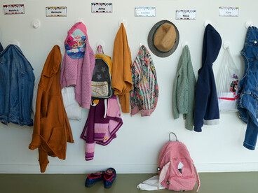 Des manteaux accrochés dans un couloir d'école