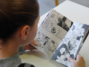 Une élève en train de lire un manga